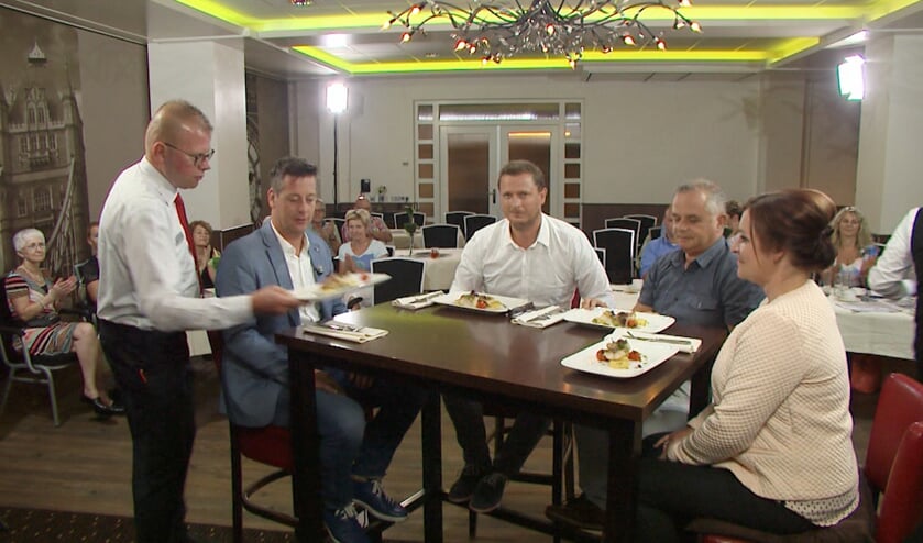 Presentator Rob van Lieshout samen met de drie gasten aan tafel.