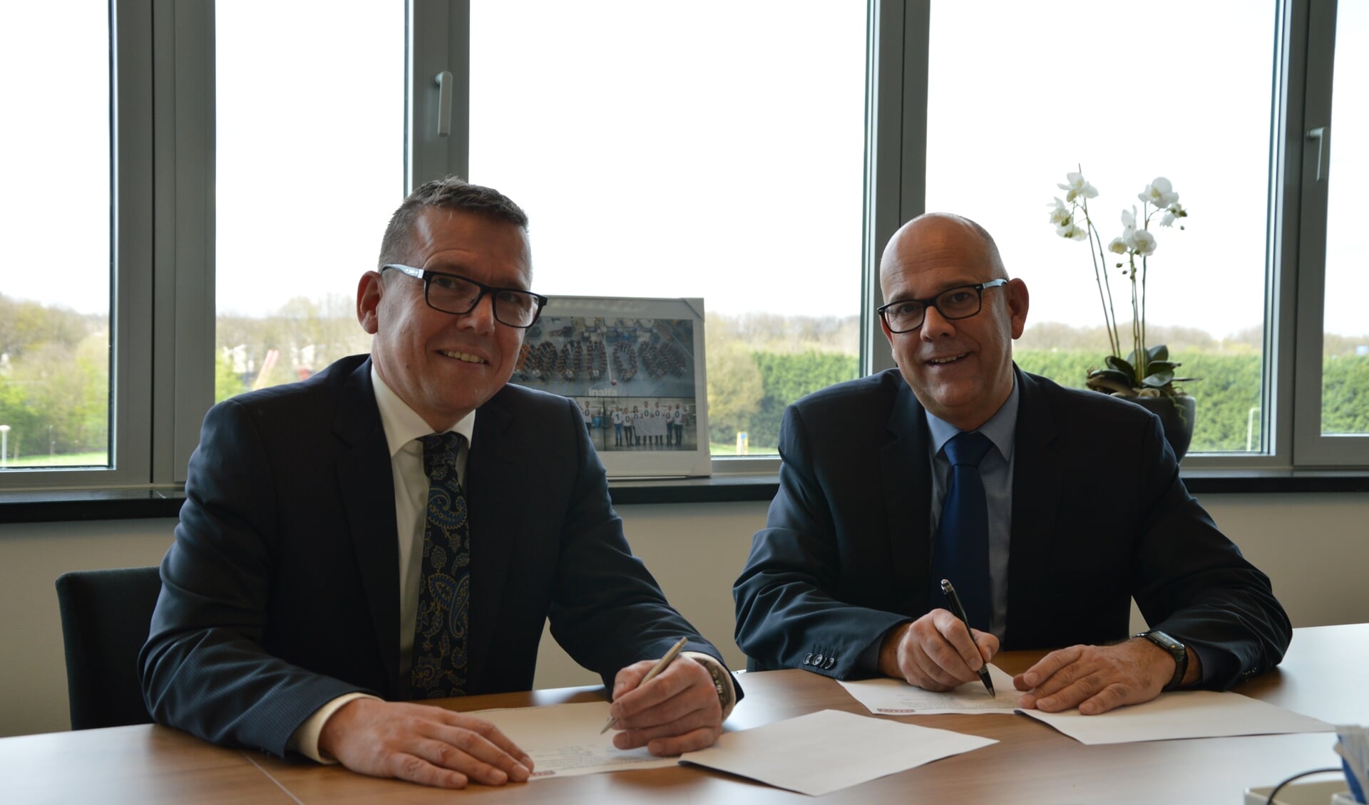 Frank Vanmaris, CEO Inalfa Roof Systems, en Frank van Gool, CEO OTTO Work Force, ondertekenen het contract.