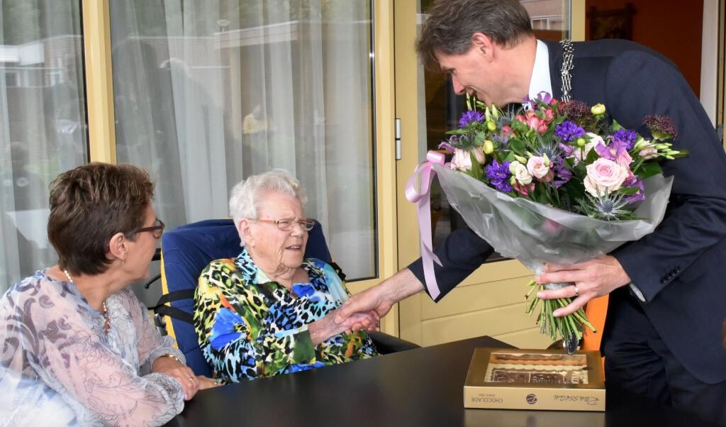 Locoburgemeester Jan Loonen zet Truda Voermans-van Mil in de bloemetjes. 
