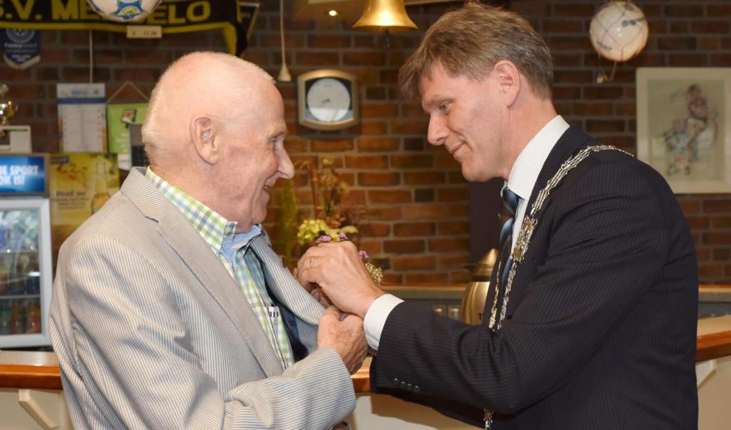 Locoburgemeester Jan Loonen speldt de penning op bij Jan Janssen. Foto: Hoedemaekers.