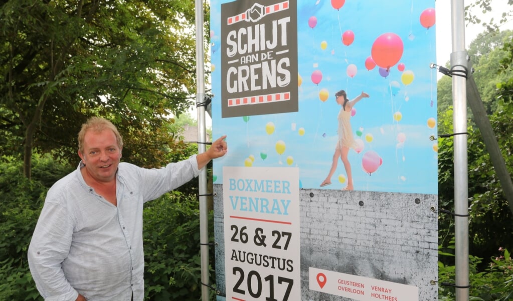 Jan Fleurkens bij het affiche van Schijt aan de Grens, het festival begint over twee dagen.