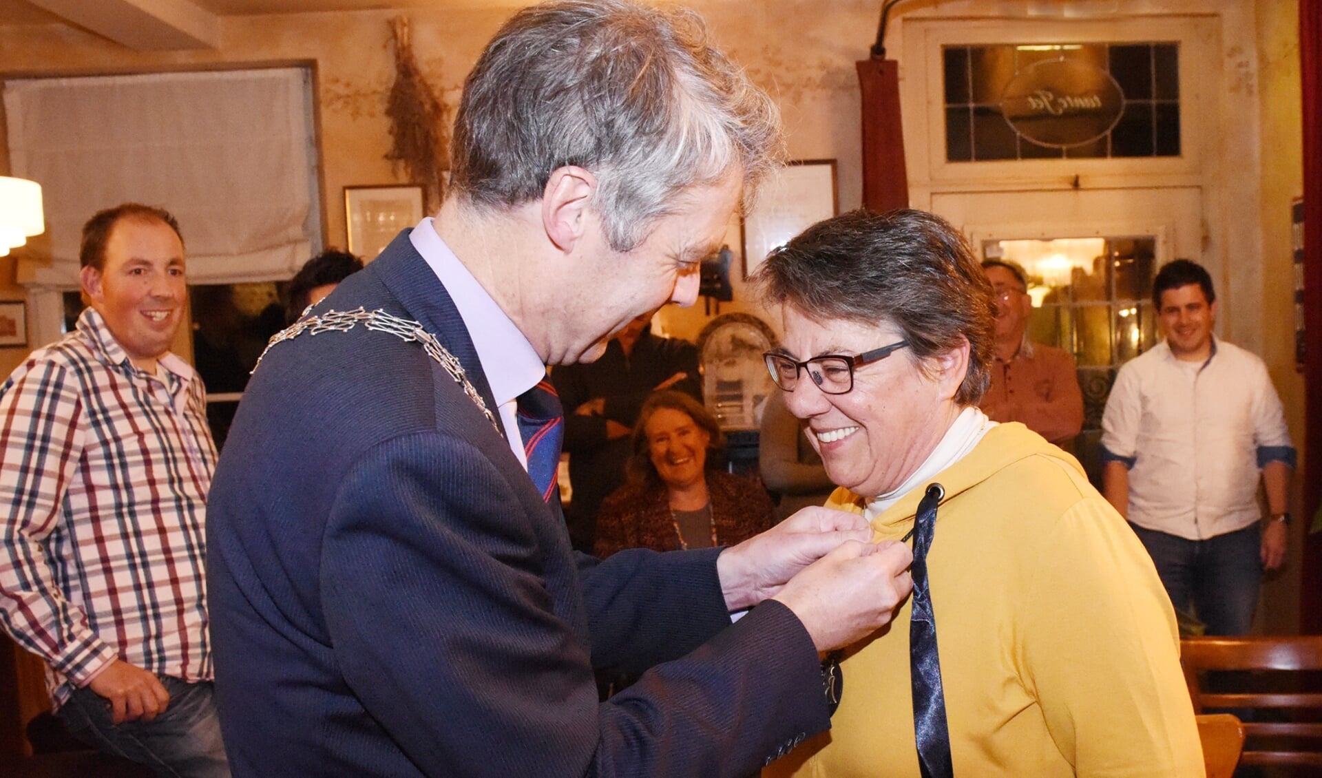 Burgemeester Hans Gilissen speldt de waarderingspenning bij Mariet van Gerven-Pijpers op. Foto Hoedemaekers Venray