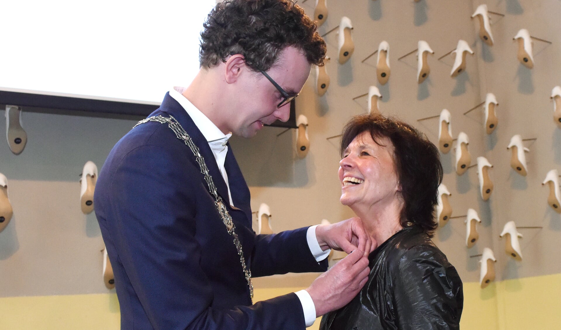 Locoburgemeester Martijn van der Putten speldt de onderscheiding bij Marieke Sieraad op. Foto: Hoedemaekers. 