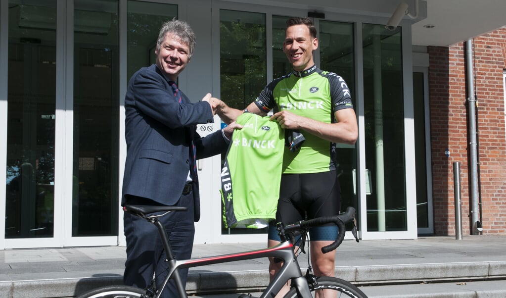 Vorig jaar ontving burgemeester Hans Gilissen een wielershirtshirt van BinckBank Tour-ambassadeur Maarten Tjallingii. Foto; archief Peel en Maas. 