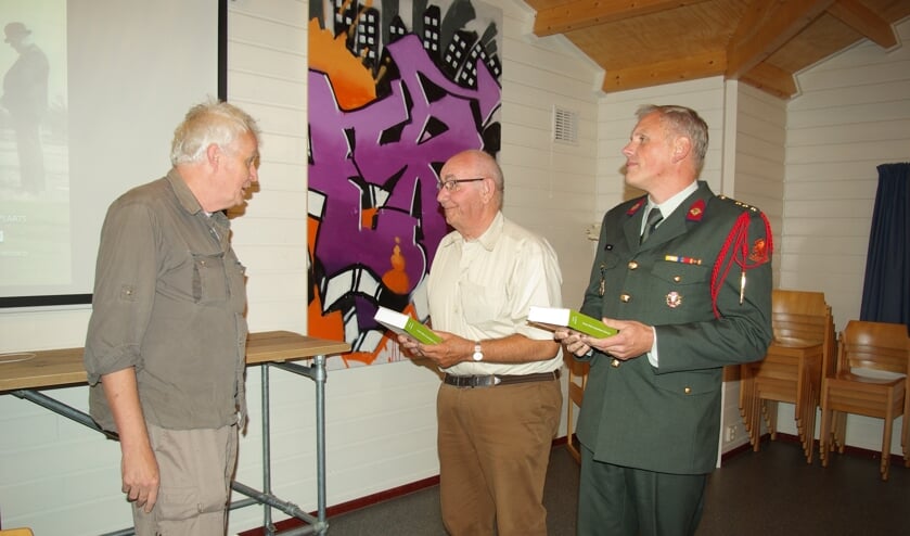 Hans Sakkers overhandigt de eerste twee boeken.