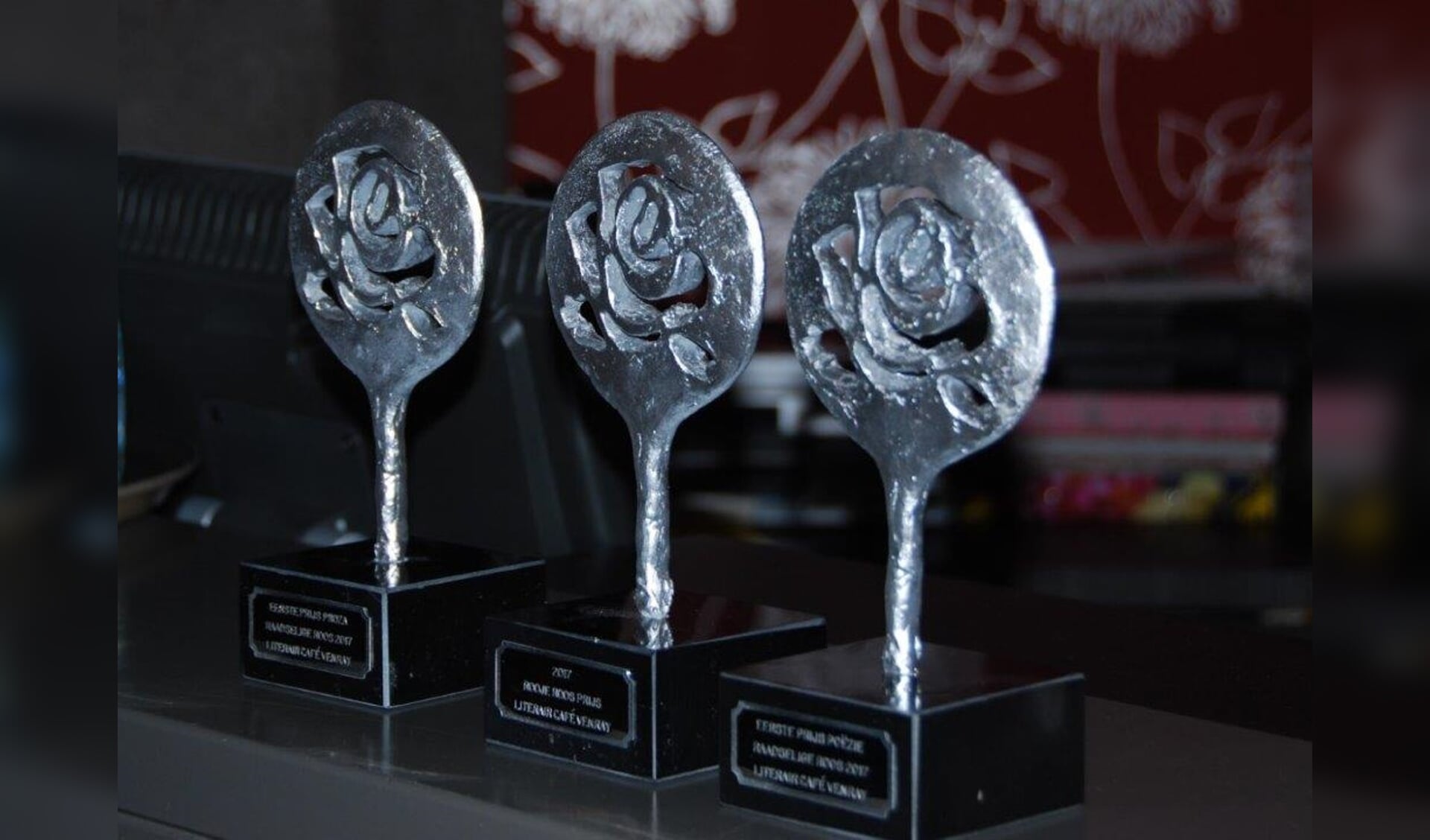  De drie trofeeën voor de eerste prijswinnaars in de categorieën proza en poëzie en de winnaar van de publieksprijs poëzie, de Roojse Roos.