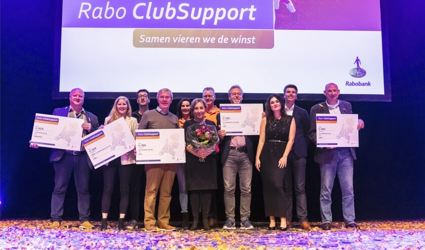 Vertegenwoordigers van de clubs met hun cheques, samen met Rabo-collega's Susanne Stevens, Twan Litjens, cabaretière Karin Bruers, zangeres Nienke Wijnhoven en directeur Edwin de Bruijn (tweede van rechts). Foto; Paul Poels.