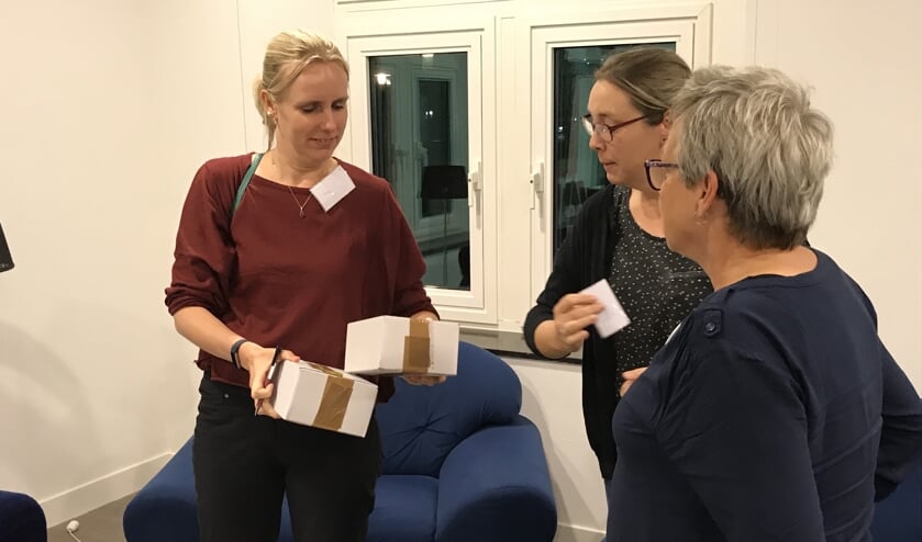 Een medewerker van het RIVM reikt de meetapparatuur uit aan de vrijwillige deelnemers aan het project.