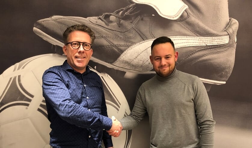 Voorzitter Herman Rutten (links) en trainer Fenne Smits beklinken de contractverlenging met een ferme handdruk.