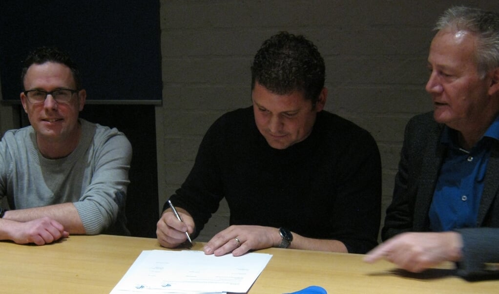 Patrick Wijnen (midden) zet zijn handtekening onder toeziend oog van Thijs Peeters (penningmeester, links) en Noud Creemers (voorzitter, rechts).

