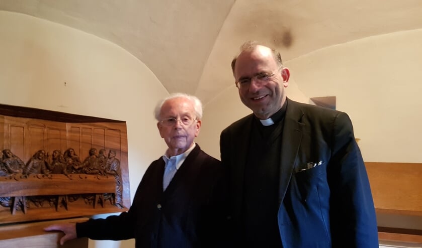 Jan Stoffels (links) en Pastoor Huub van Horne bij het houtsnijwerk.