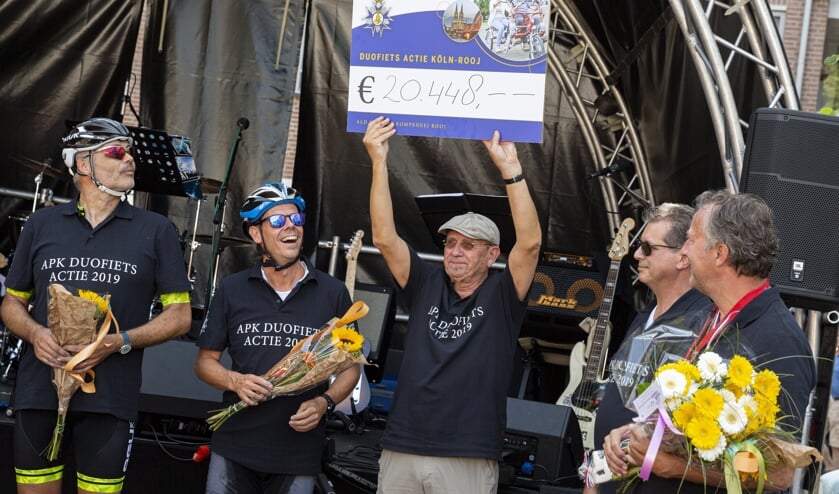 Hans Schambergen van de Ald Preense Kompeneej toont trots de cheque aan het publiek op het Schouwburgplein.