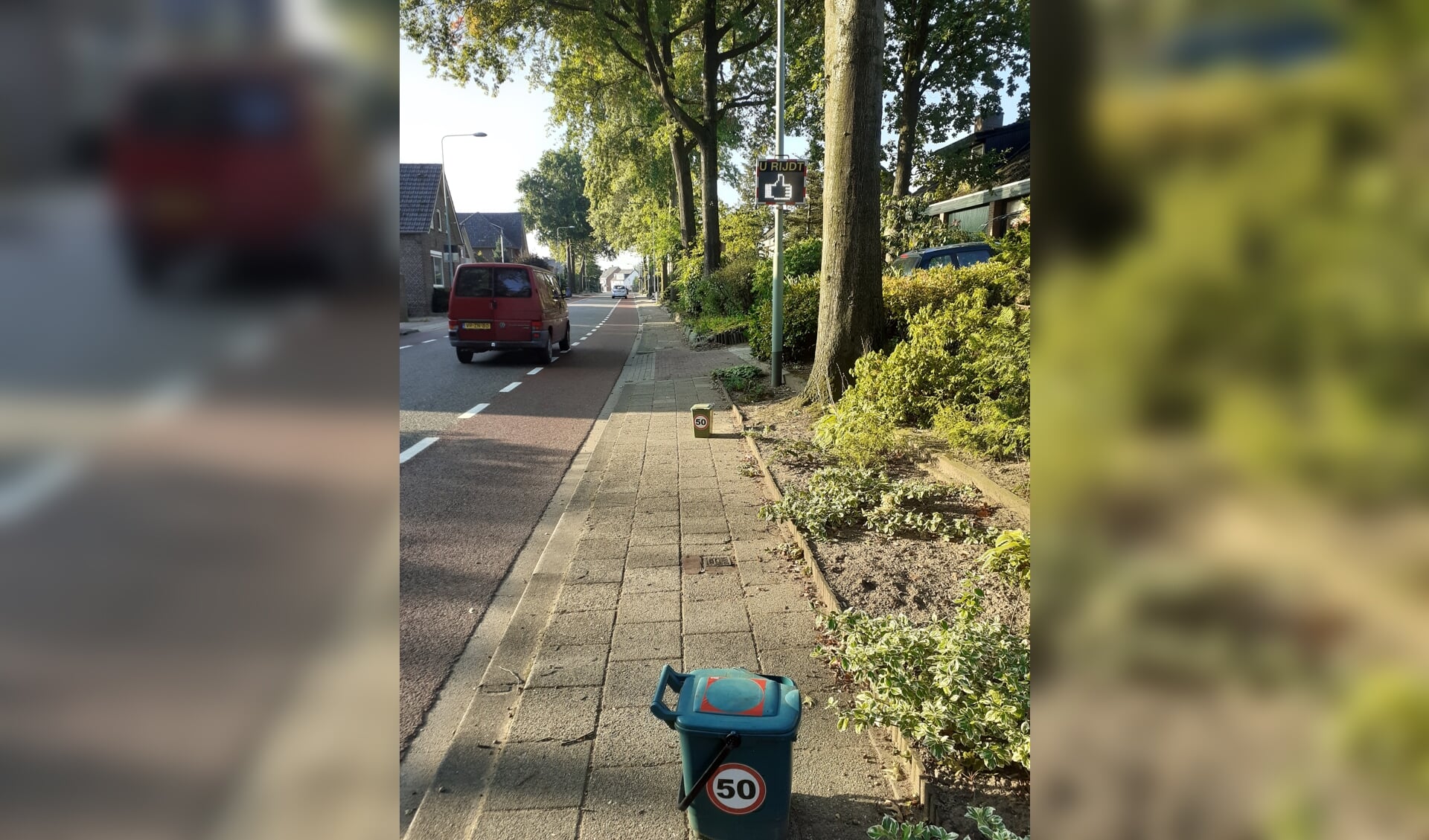 Groene afvalbakken met de 50 km-stickers langs de Meerlose Hoofdstraat.
