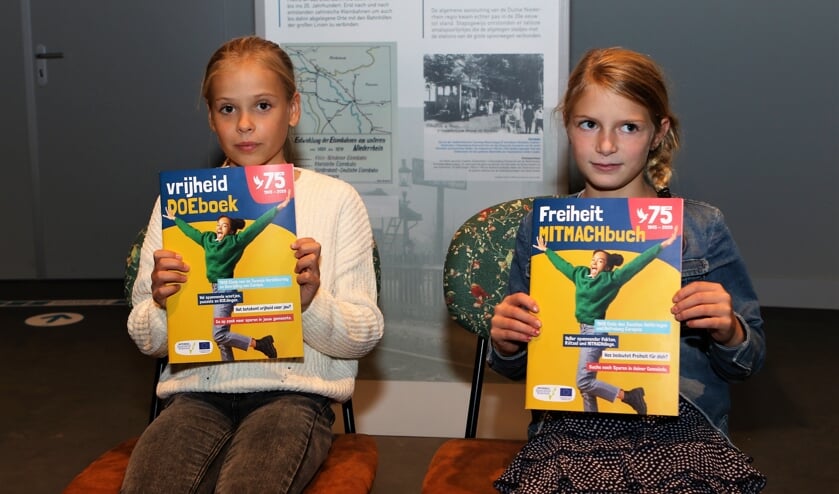 <p>Lisa uit Venray (links) en Carlotta uit het Duitse Weeze kregen het eerste exemplaar van het nieuwe doeboek.</p>