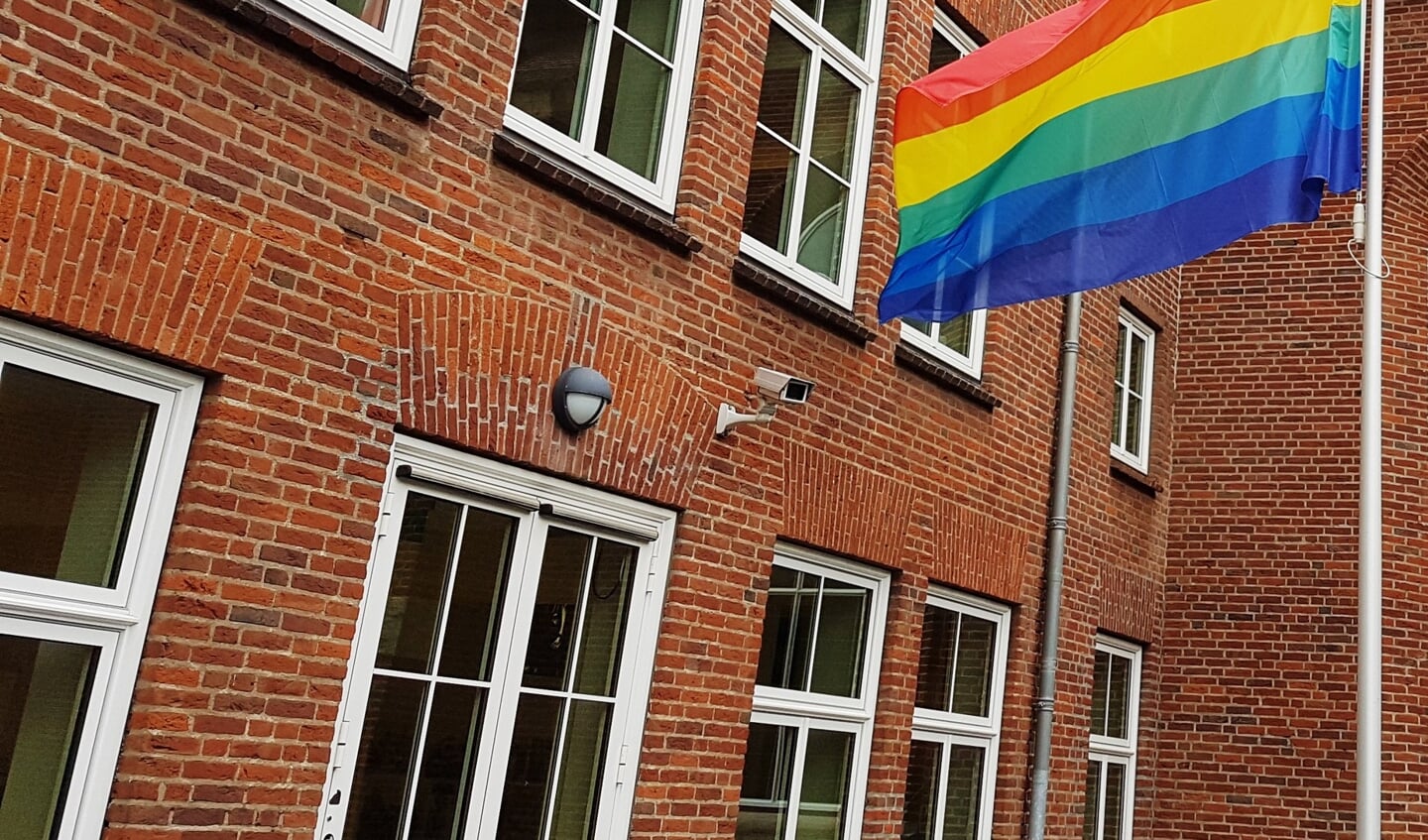 De regenboogvlag in top.