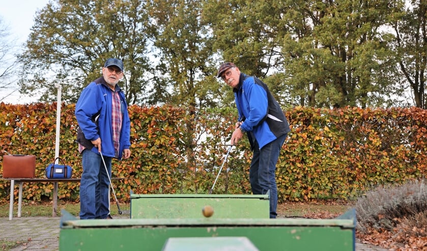 <p>Jan van der Hagen (rechts) en Jan Engels volgen de gespeelde midgetgolfbal naar de hole.</p>