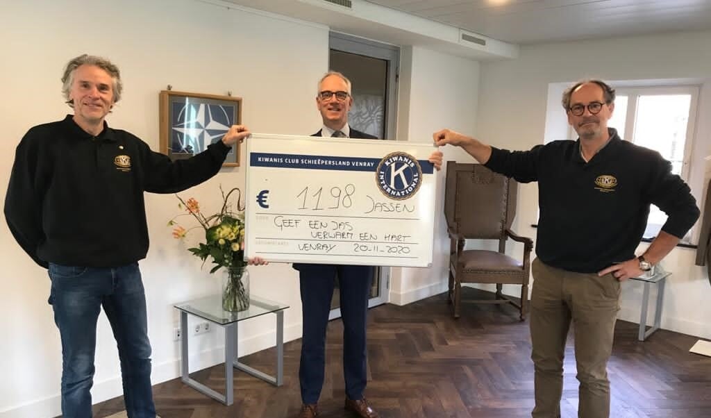 Leden van Kiwanisclub Schieëpersland overhandigen burgemeester Winants symbolisch de 1198 jassen.
