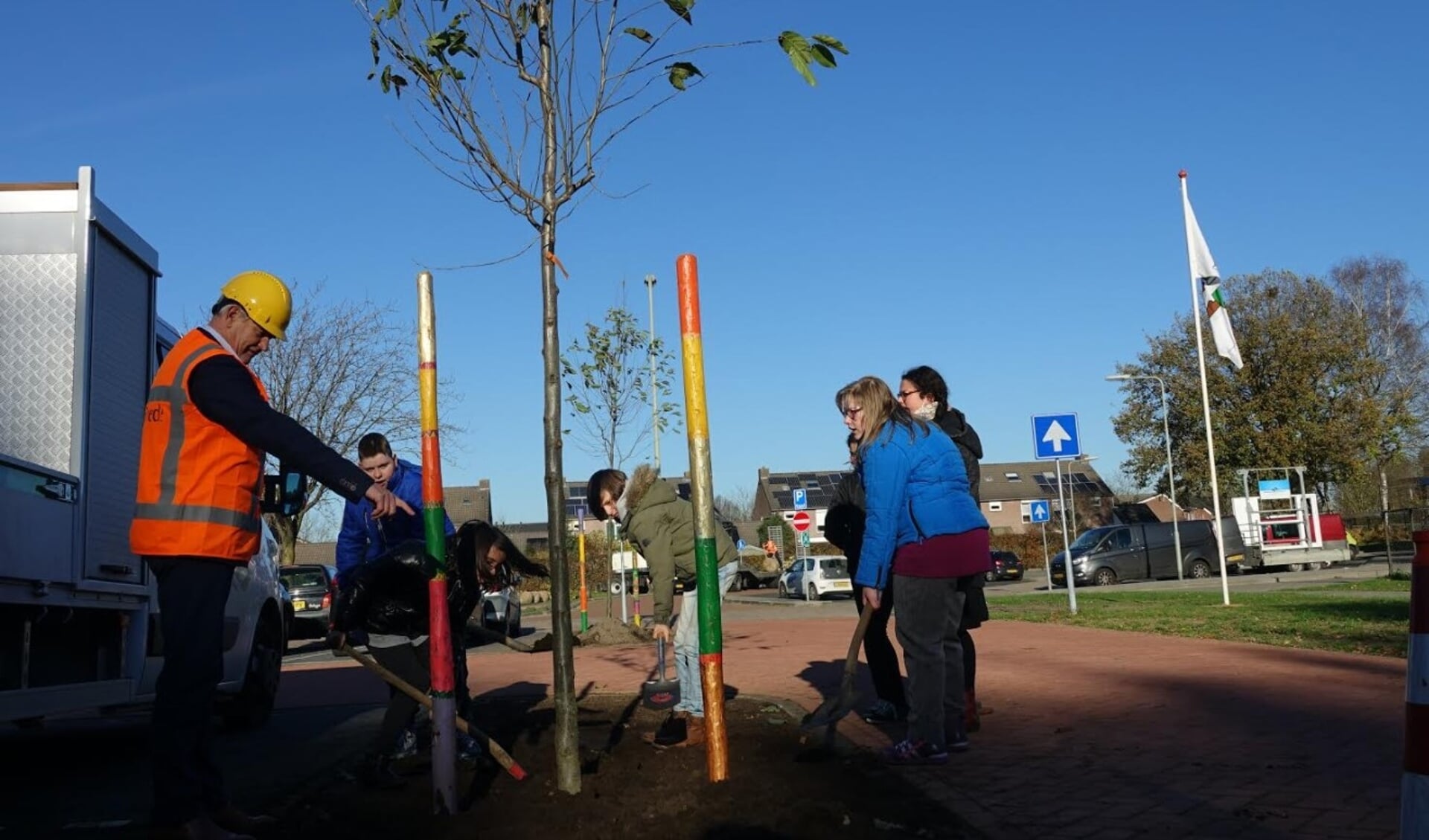Kinderen helpen de wethouder met het planten van een boom