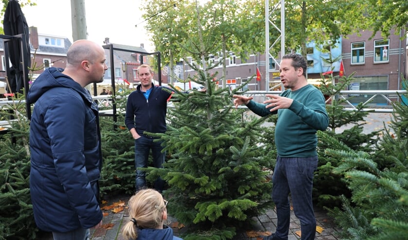 <p>Gijs Schapendonk (rechts) en Giel van Driel (midden) verkopen kerstbomen.</p>