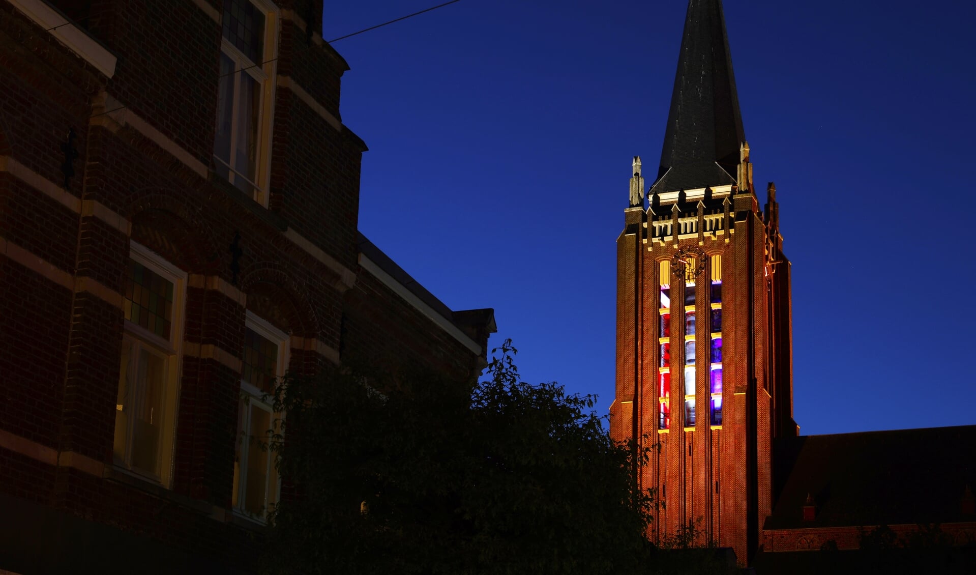 De rood-wit-blauw verlichte toren van de Grote Kerk. 