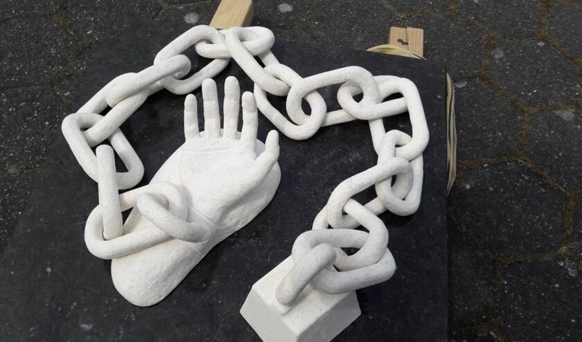 Het kunstwerk, gemaakt van grafsteen: Geketend.