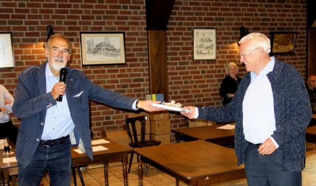 Hens Borkent (links) overhandigt het eerste boek aan Karel Janssen 'de Sikkeneur'