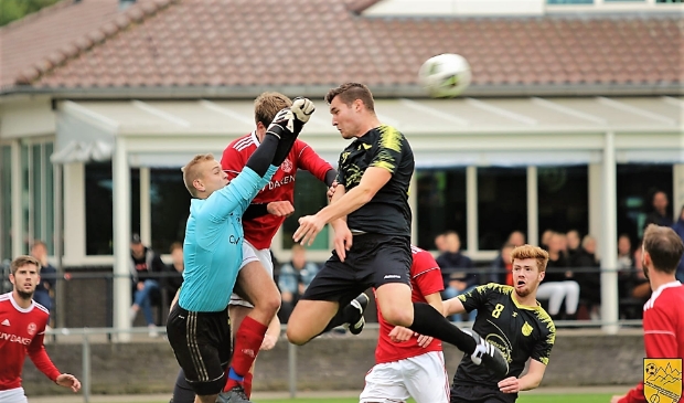 Bram van Roosmalen in een luchtduel voor de goal van Oostrum