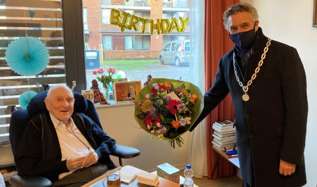 Burgemeester Teunissen bezoekt de 100-jarige pater Van Beek.