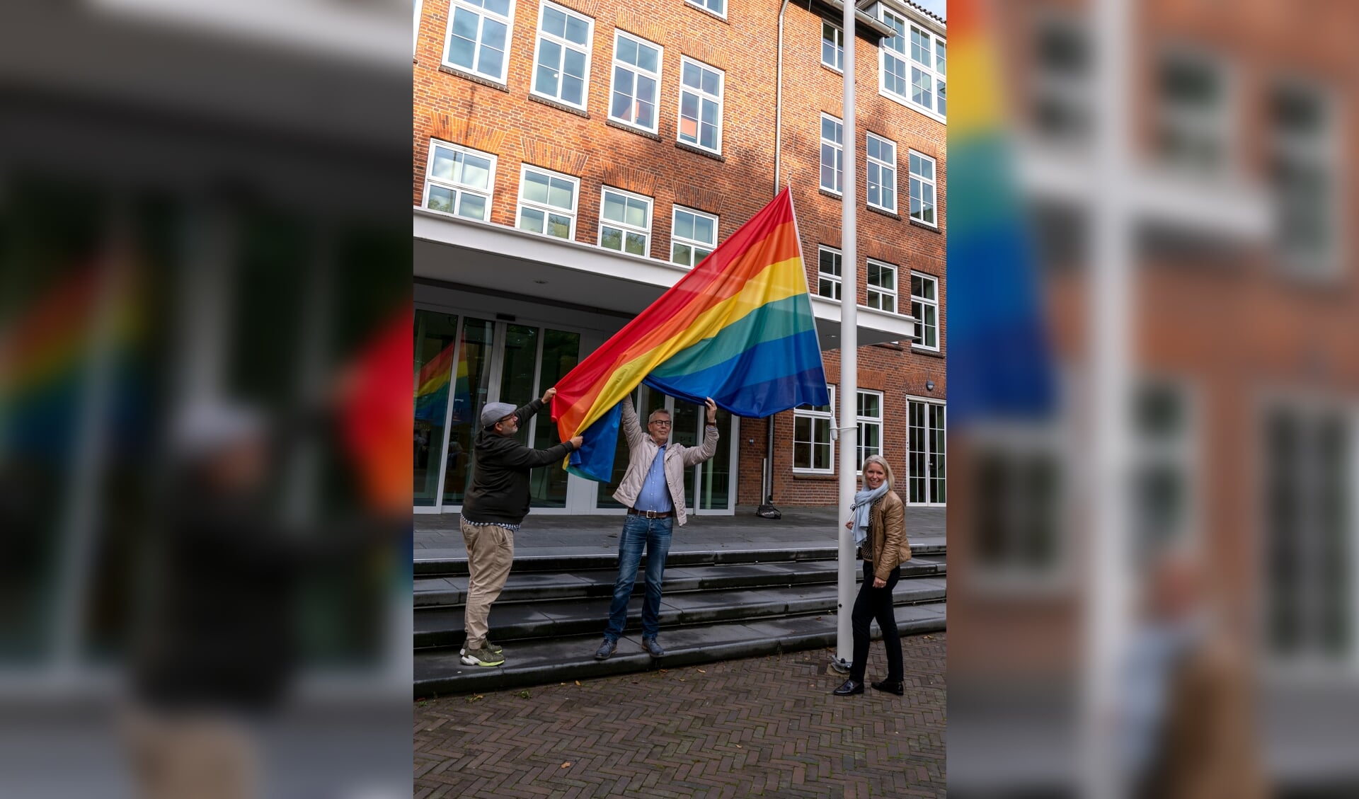 Het hijsen van de regenboogvlag, maandagmorgen bij het gemeentehuis in Venray. Vanaf links: Robert Westheim, Leo Heldens en wethouder Chantal Nijkerken, 