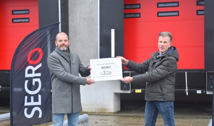 Eelco Ouwerkerk (links) overhandigt de cheque aan Paul Classens van projectgroep De Linde.