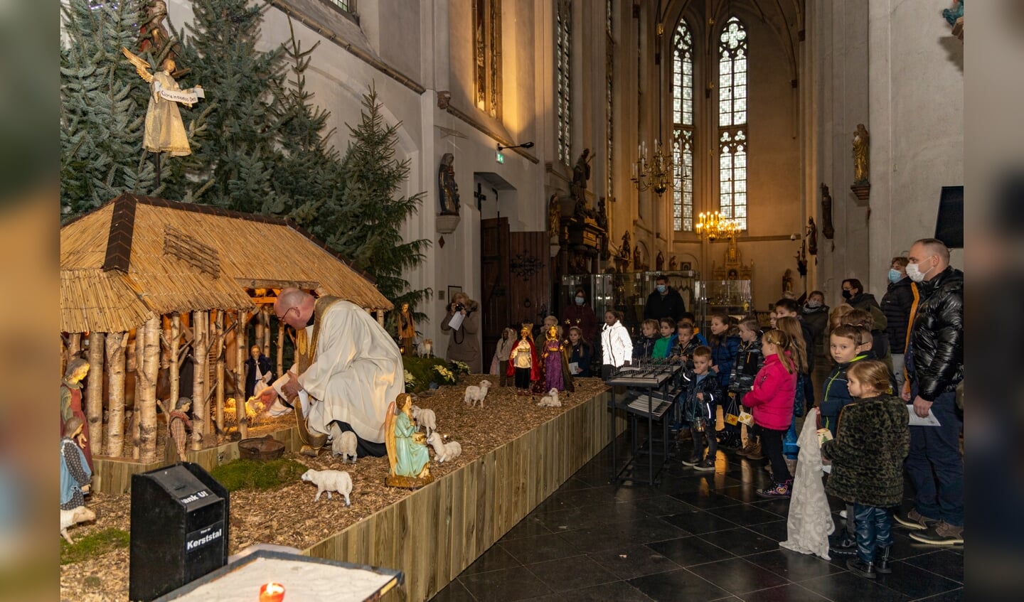 Deken Ed Smeets legt vrijdagmiddag 24 december het kindeke Jezus in de kribbe van de Grote Kerk in Venray.  