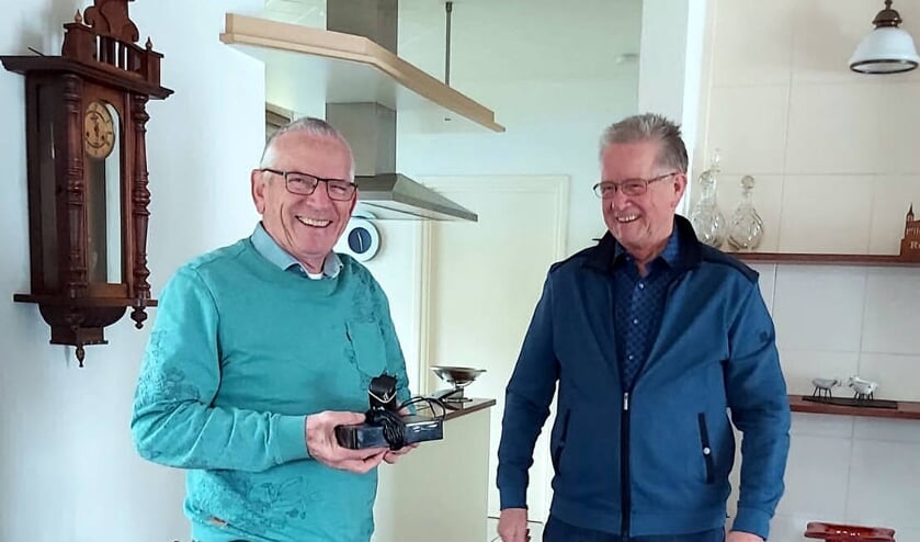 <p>Henk Janssen (rechts) overhandigt de externe schijf met het nieuwe digitale archief van Oostrum aan Joos Linskens.</p>