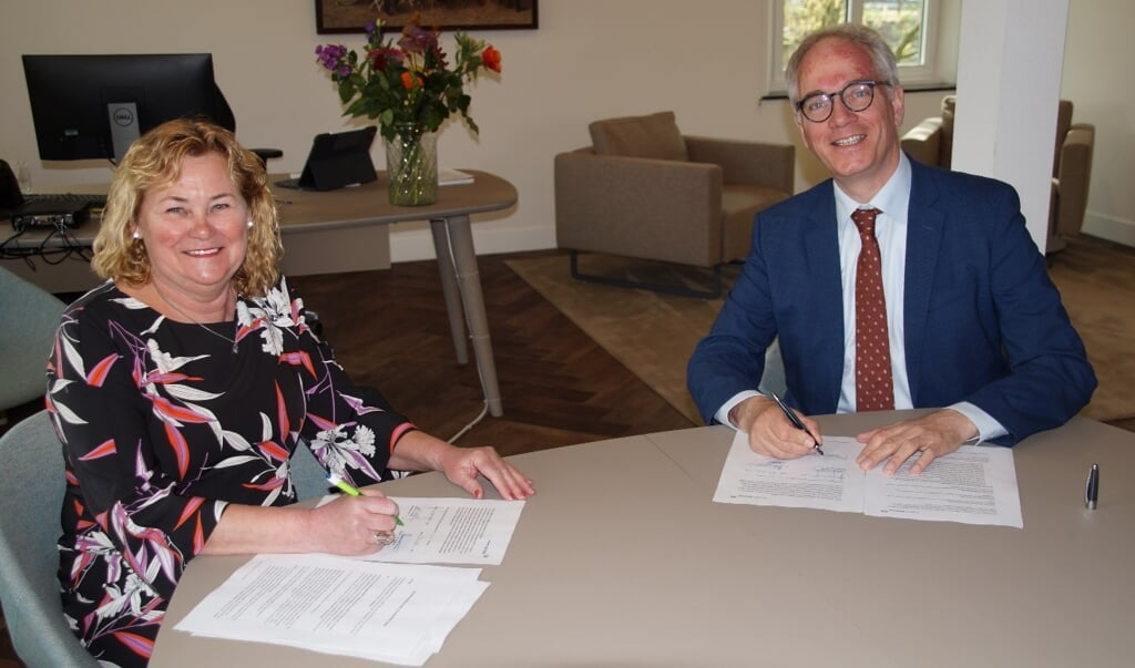 Annie Timmermans, voorzitter Stichting Antoniushof Veulen, en burgemeester Luc Winants zetten hun handtekening.