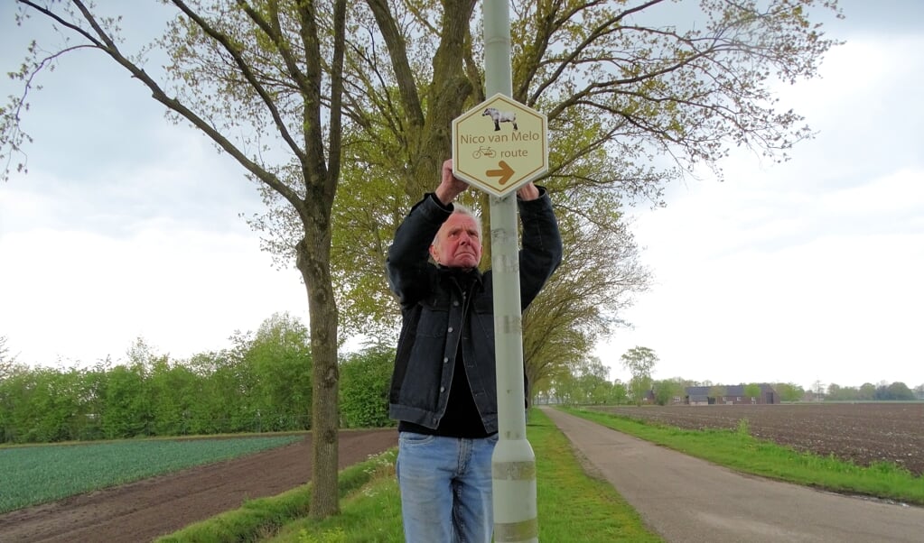 Vrijwilliger Jan Weijs bevestigt een routebordje voor het nieuwe traject.