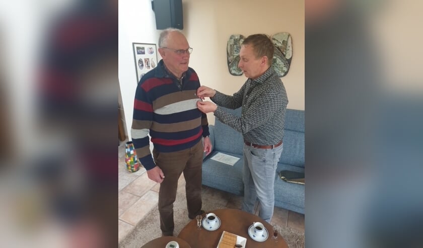 <p>Voorzitter Diederik Nijenhuis speldt Hans Gommans zijn jubileumspeld op. </p>