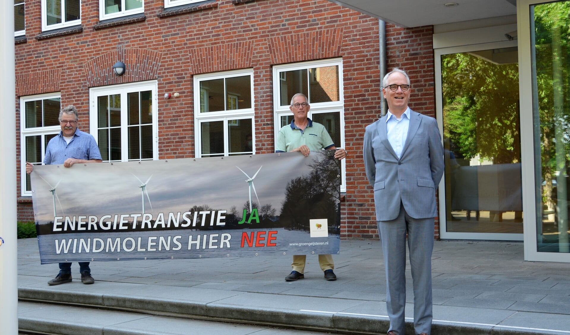 Harrie Eijssen (links) en Ad Wijnhoven met protestspandoek, rechts burgemeester Luc Winants. 