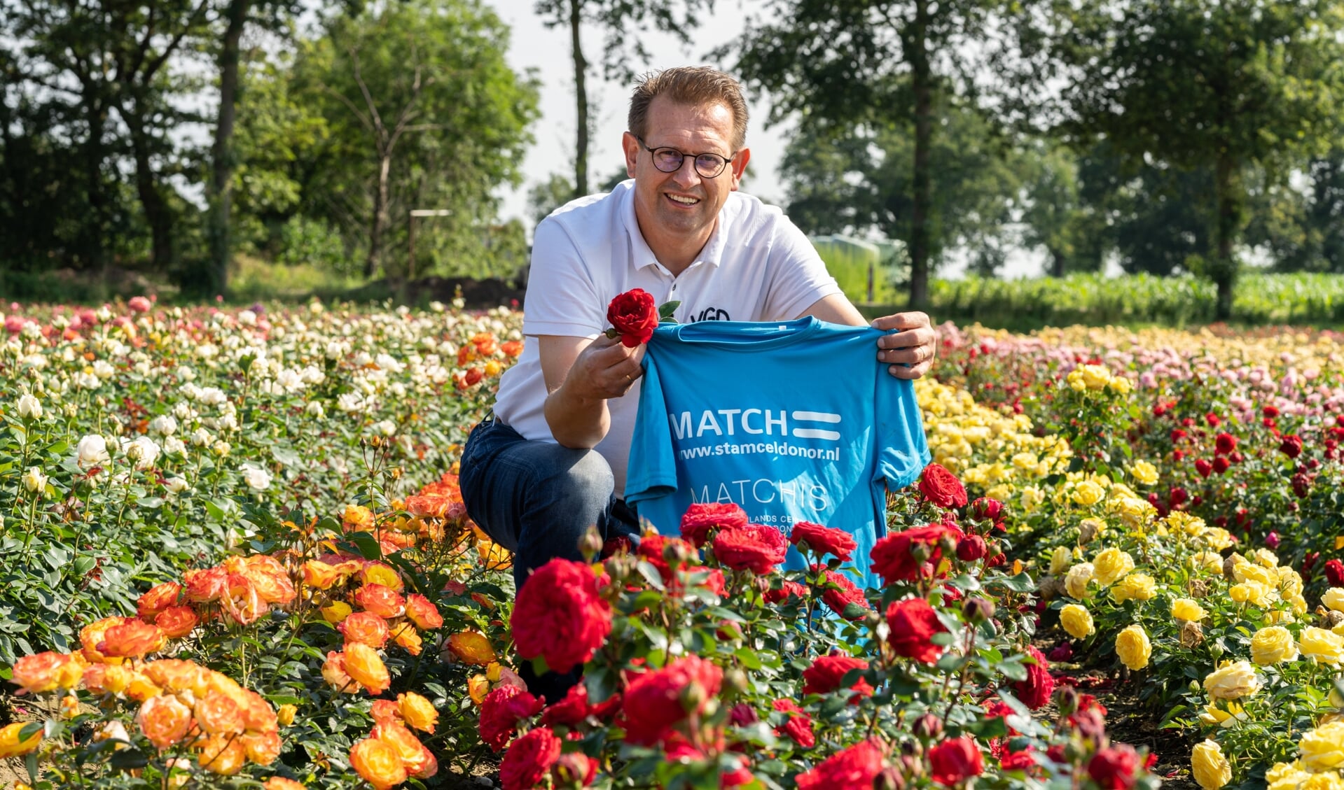 Patrick Wijnhoven zitten trots bij zijn rozen en in het bijzonder de rode Rosa Matchis.