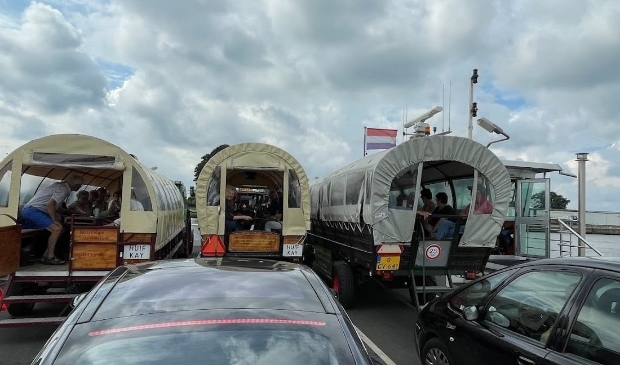 Met de huifkarren op de pont over de Maas