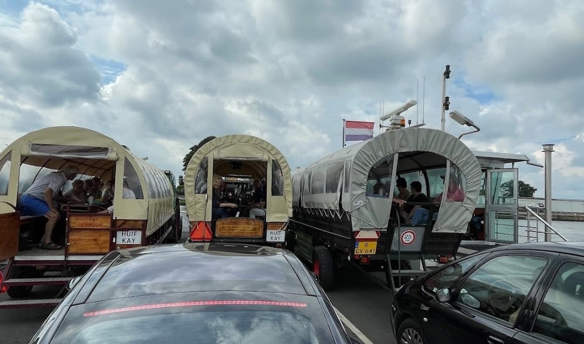 Met de huifkarren op de pont over de Maas