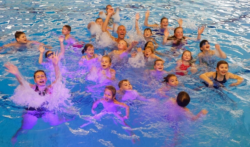 <p>Maarten van der Weijden zorgt woensdagmiddag in het zwembad in Venray tussen de kinderen voor het nodige waterplezier.</p>