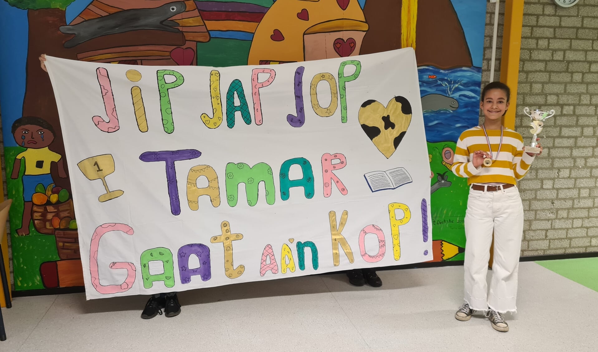 Een trotse Tamar toont de gewonnen prijs bij haar spandoek