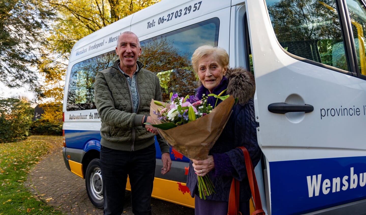 Betsy Adriaansens ontvangt als jubileumpassagier een bosje bloemen van chauffeur Wiel Duijkers.
