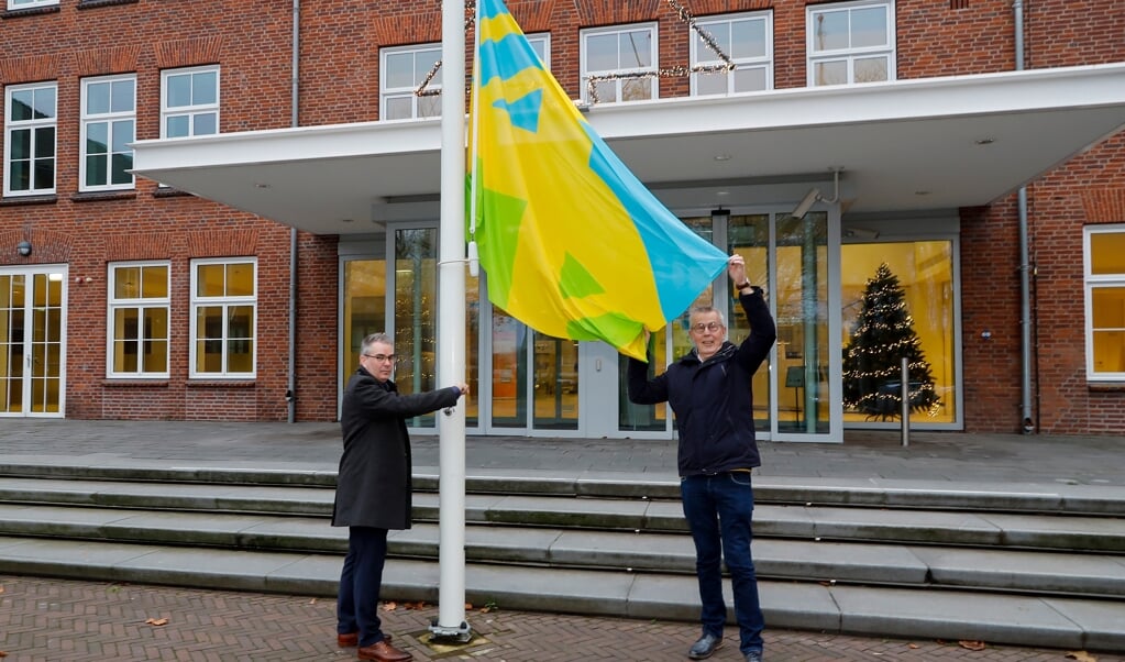 Wethouder Martin Leenders hijst de Mensenrechtenvlag in top met hulp van Leo Heldens. 