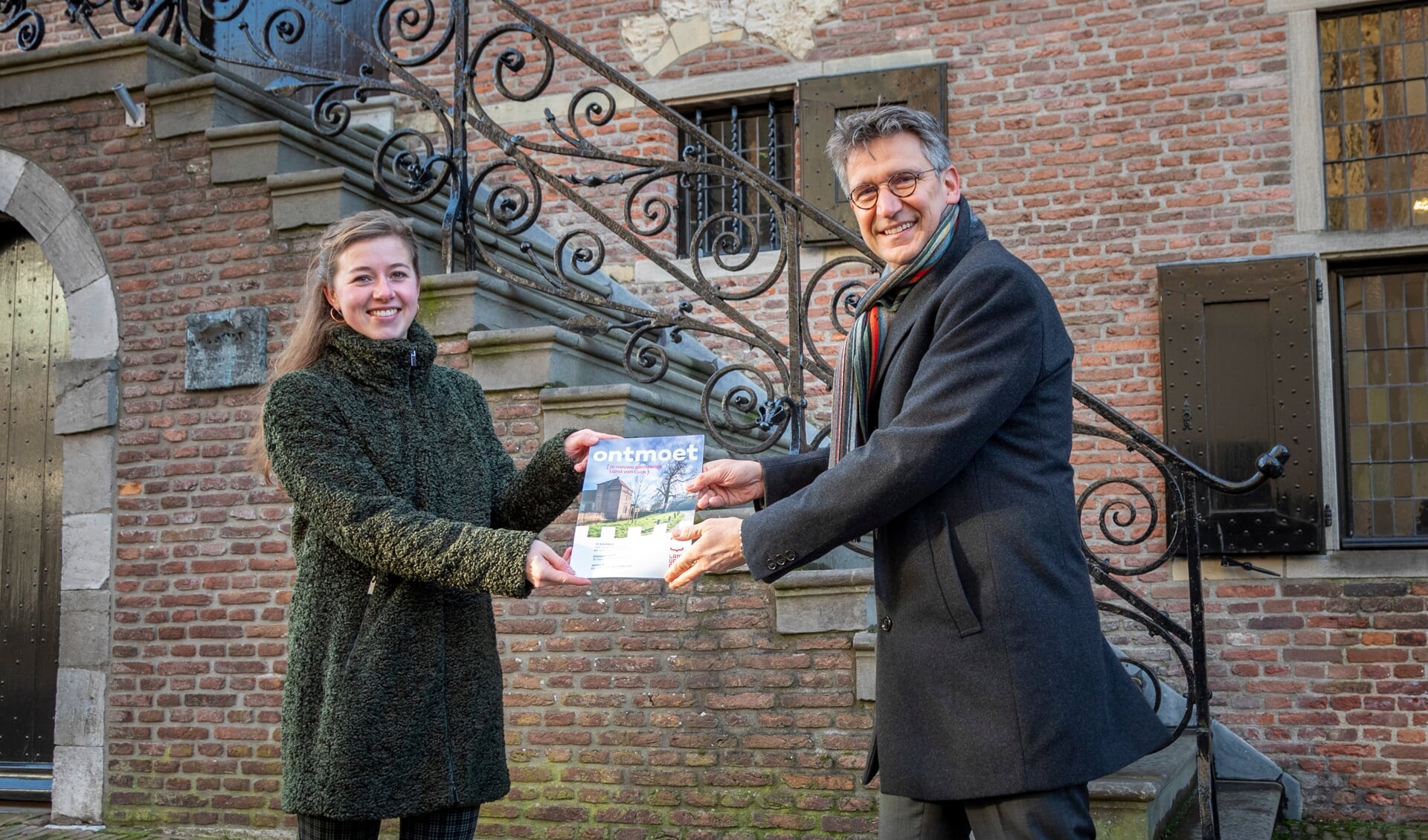 Waarnemend burgemeester Wim Hillenaar reikt het eerste exemplaar van Ontmoet uit aan Anne Hirdes.