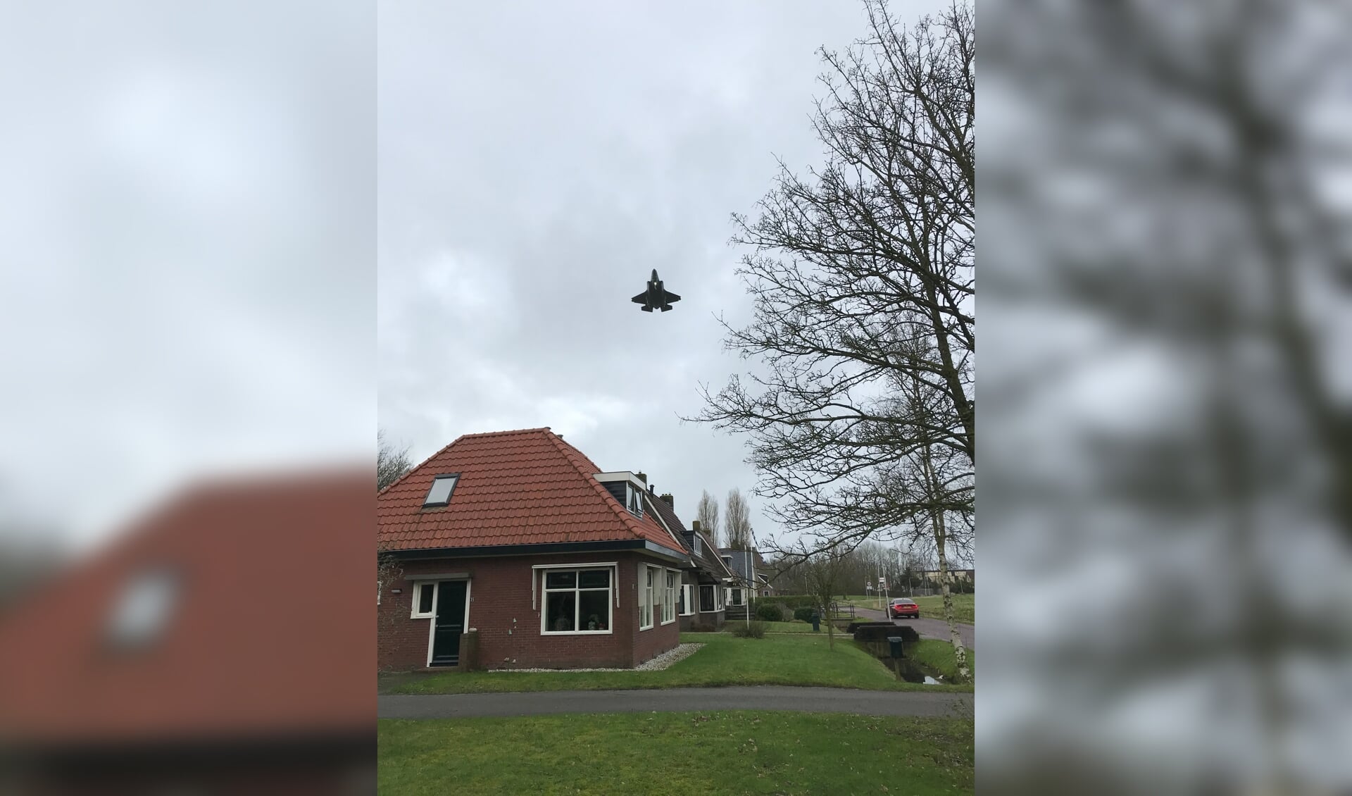 Een F-35 scheert over vlak over de daken in het Friese dorp Jelsum. 