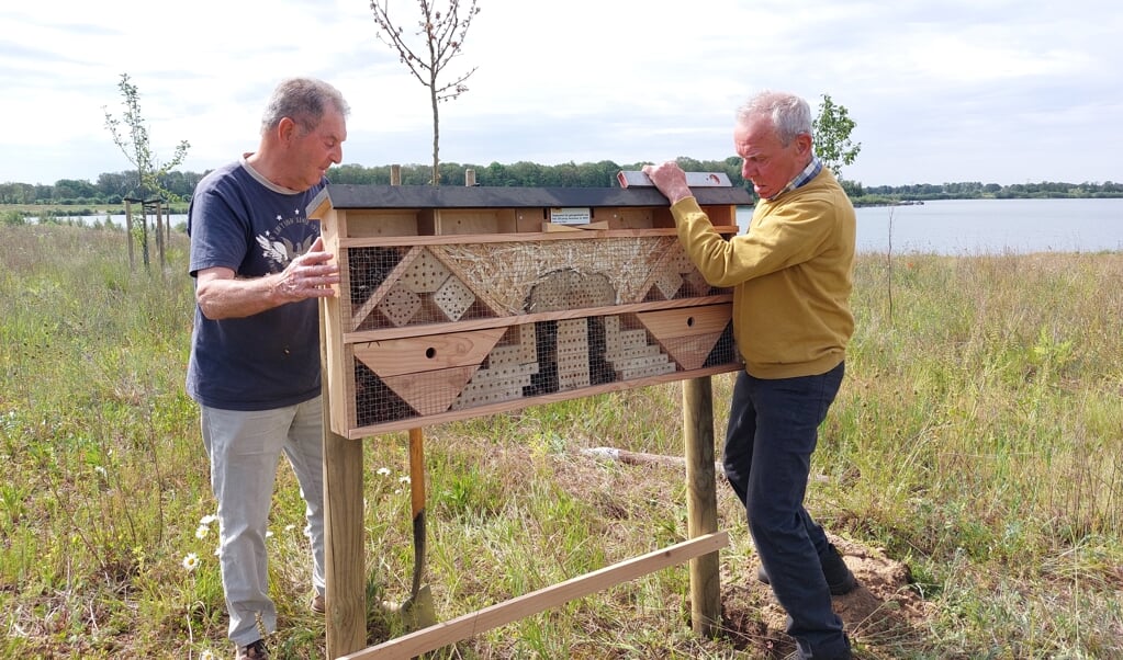 Hay Strijbos (l.) en Jan Weijs plaatsen een insectenhotel aan de Diepeling.