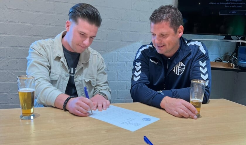 Kevin van Bakel zet zijn handtekening.