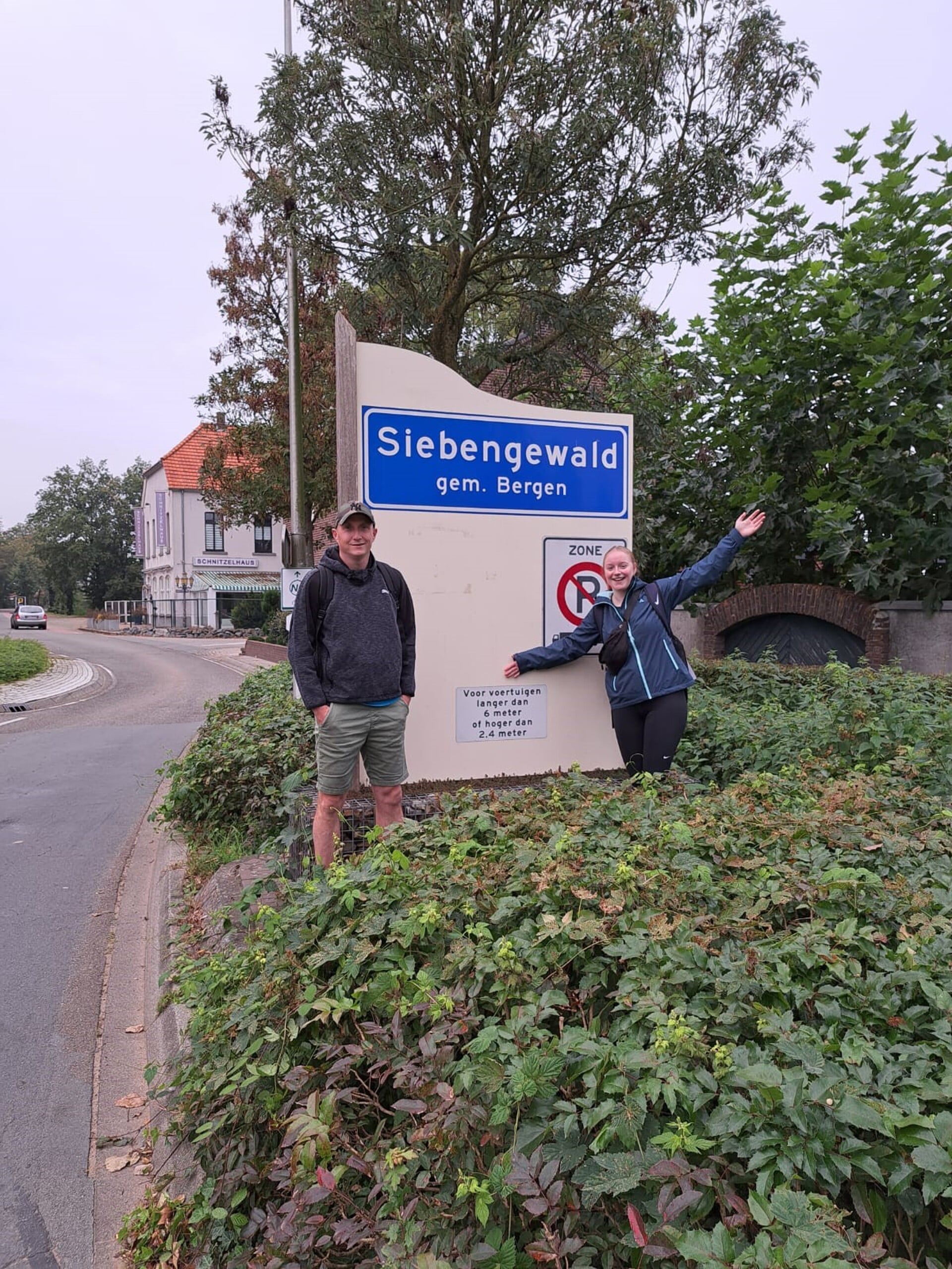 Jacky Schoofs en Peter Winkelmolen poseren bij het plaatsnaambord in Siebengewald.