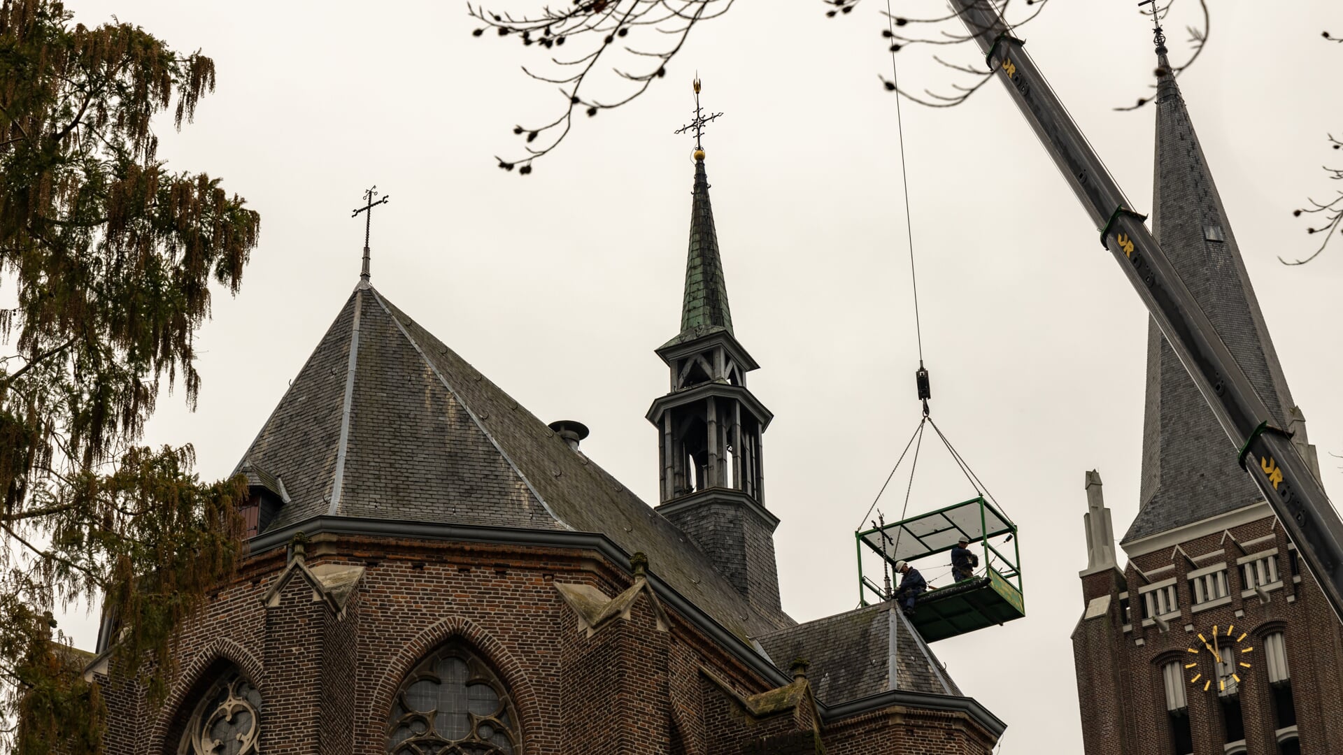 Het tweede kruis krijgt een plek op de traptoren, het eerste staat al op het kerkschip (links). 