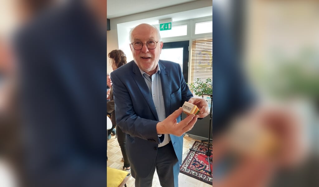 Oud-burgemeester Karel van Soest toont het  Perron 22-lustrumtaartje. 